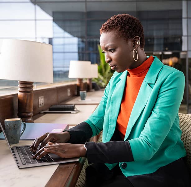 Woman working on laptop in green jacket